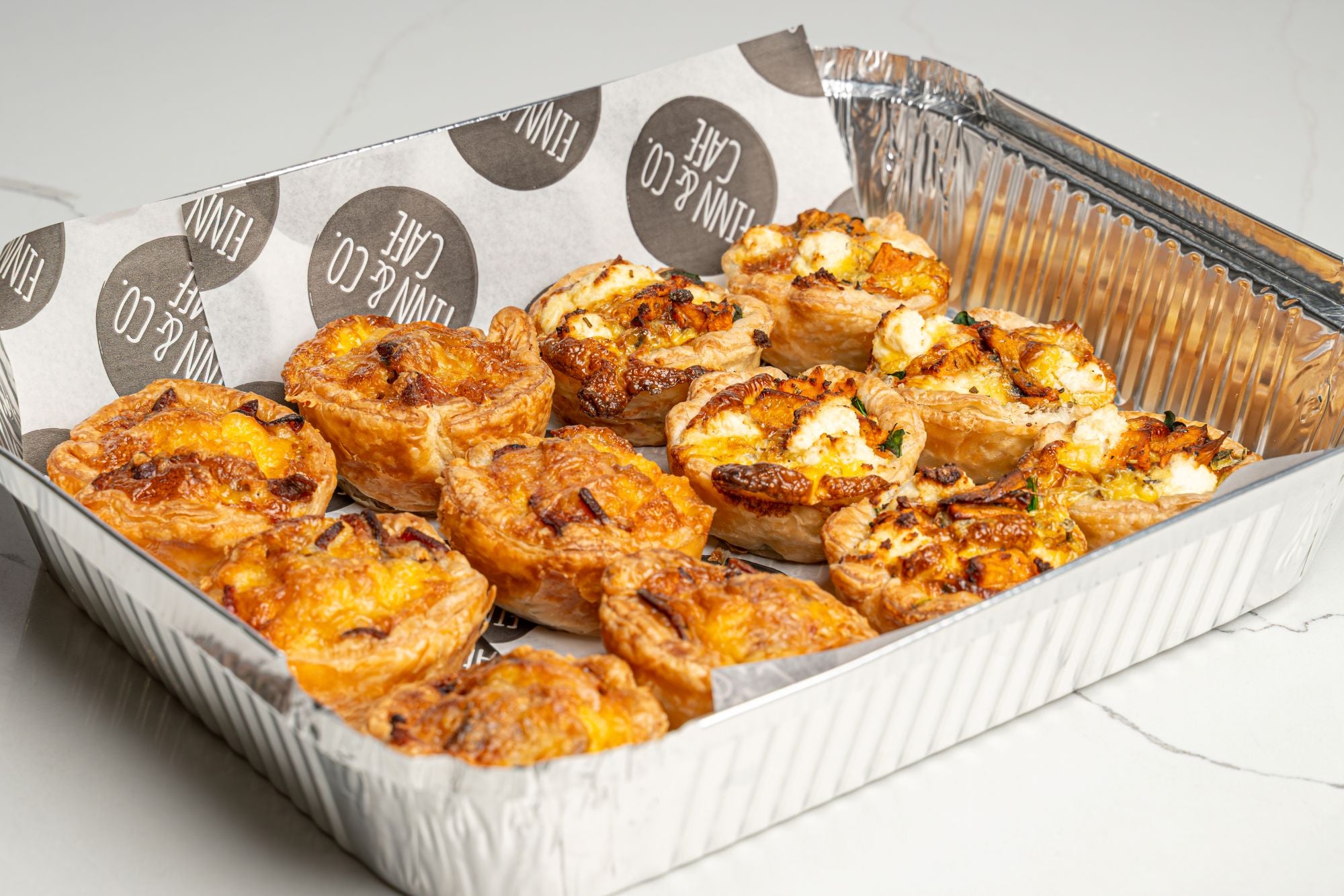 Assorted bite-sized quiches on a catering platter, ideal for corporate gatherings or casual celebrations delivery in Sydney and the Blue Mountains